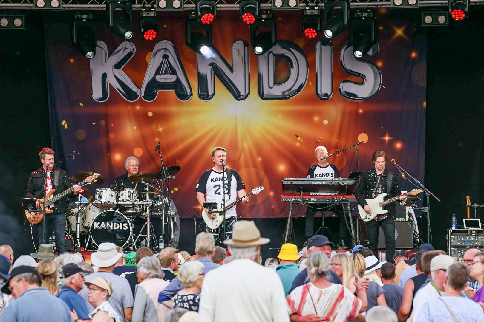 Kandis spiller på scenen med Johnny Hansen i midten og publikum foran sig